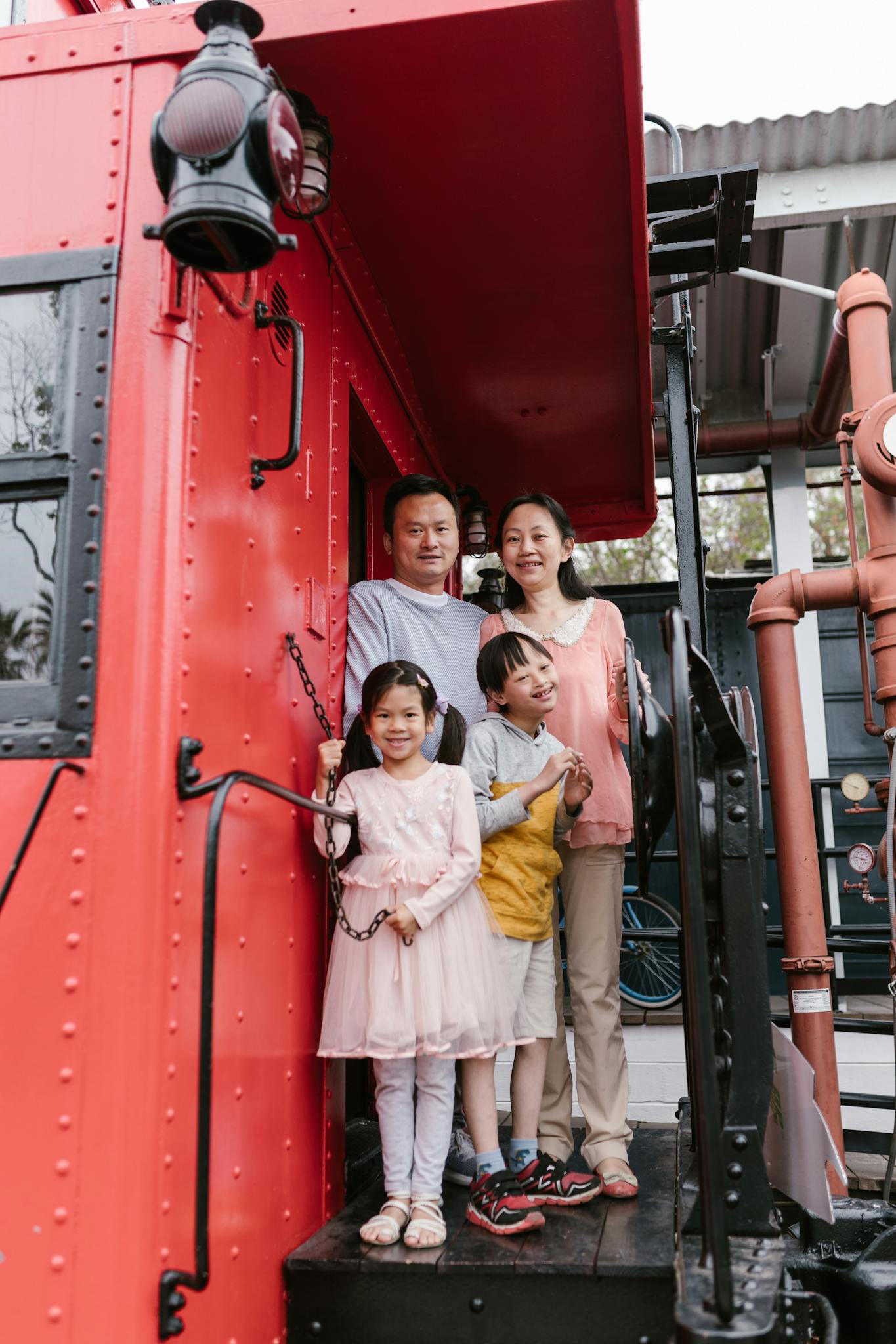 An Asian family spending quality time together on a vintage train. Smiling and bonding.