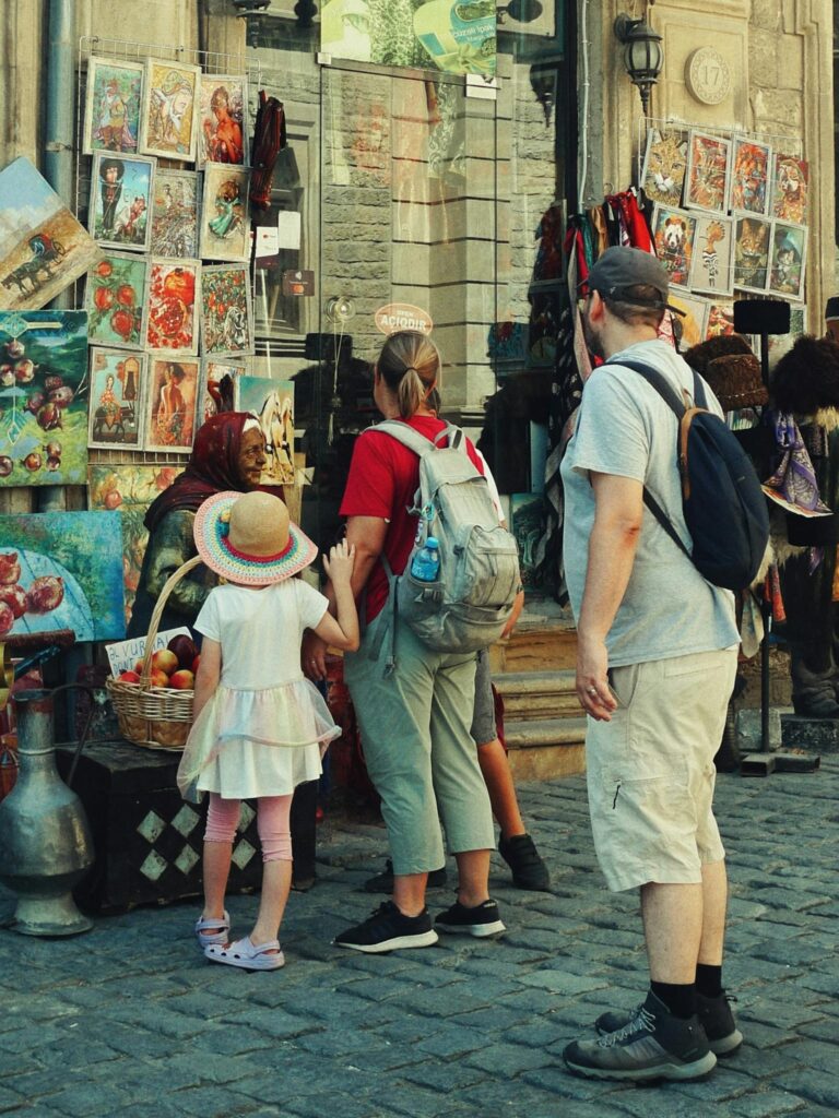 Family exploring a local art market with a child interested in street art displays and cultural crafts.